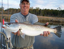 Man holding large speckled trout.
